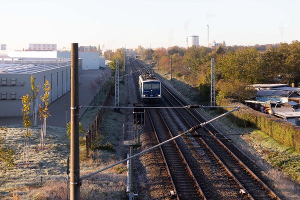 Bahn mit Industriegebiet im Hintergrund